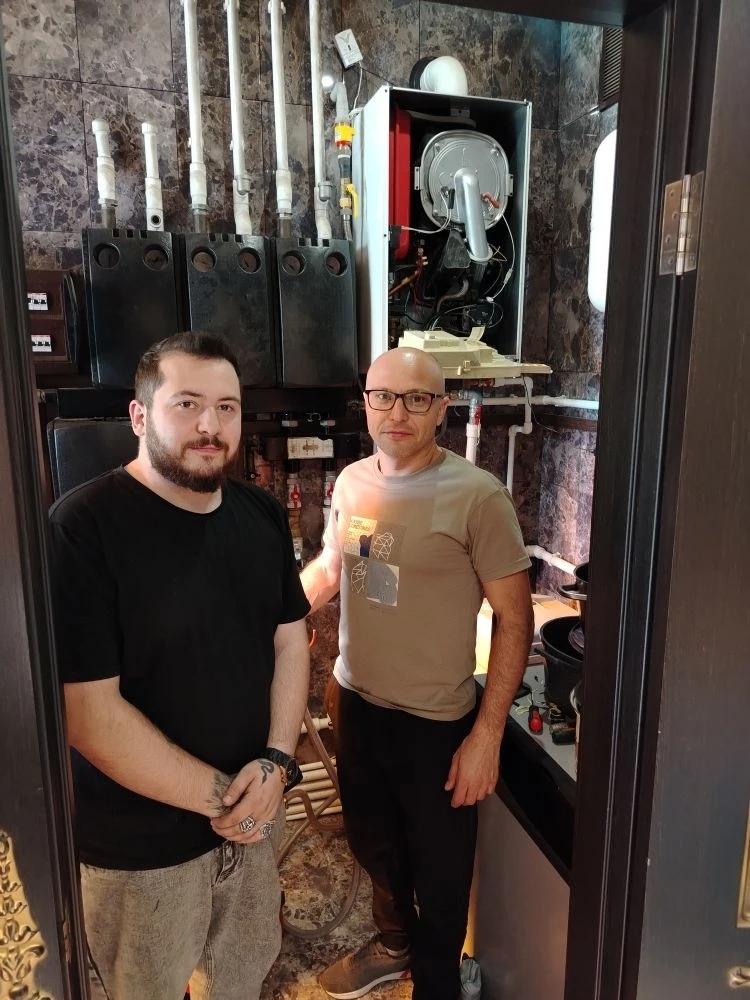 Мастер за работой с оборудованием отопления